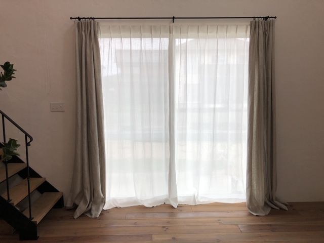 掃き出し窓に装飾レールに合わせてリネンカーテンんを設えた