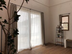 フレンチスタイルの住まいにアイアン装飾レールを取り付けた窓辺。リネン100％のカーテンで設えた